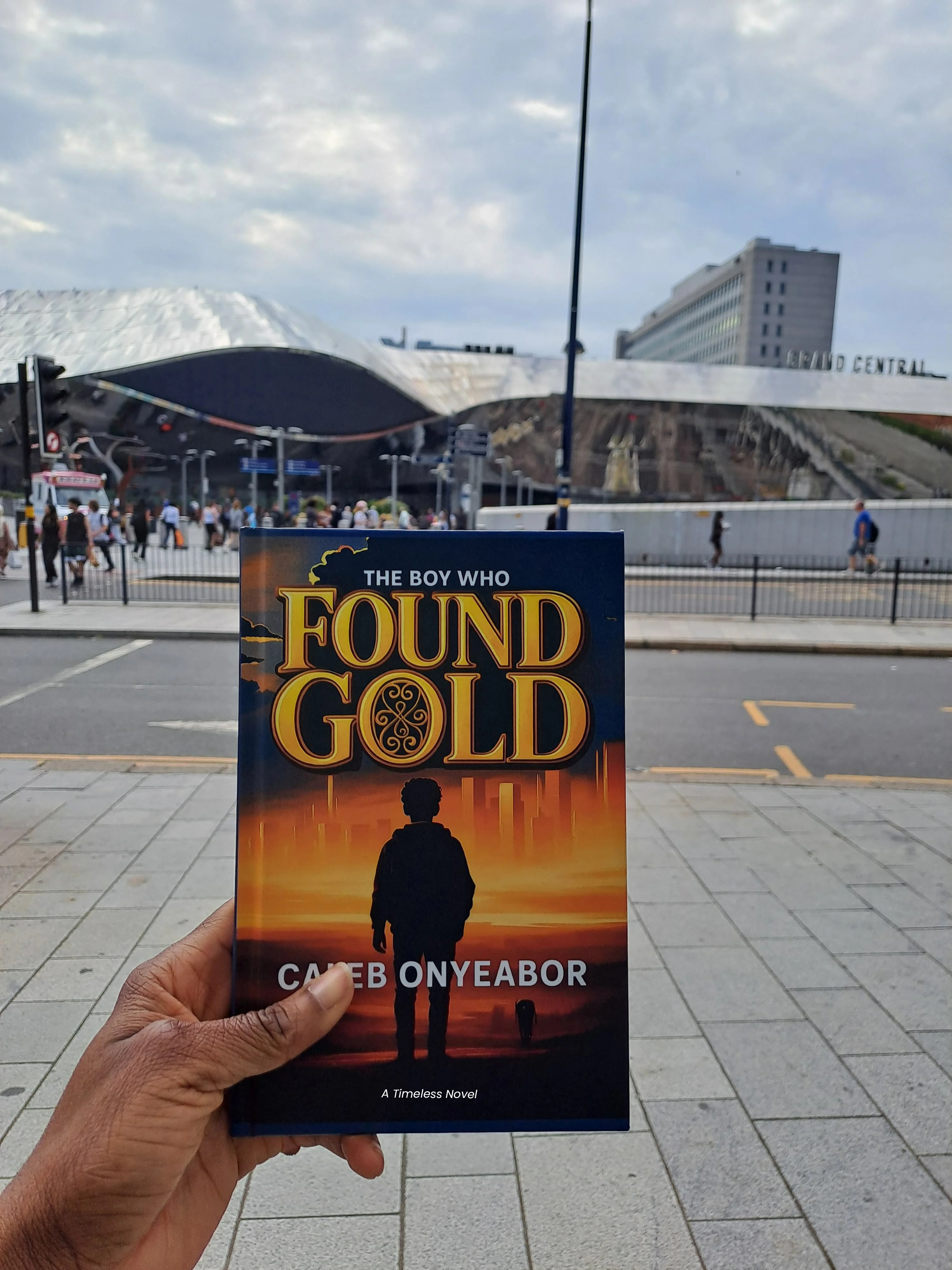 Reader holding The Boy Who Found Gold novel by Caleb Onyeabor in the United Kingdom- African literature and inspirational fiction